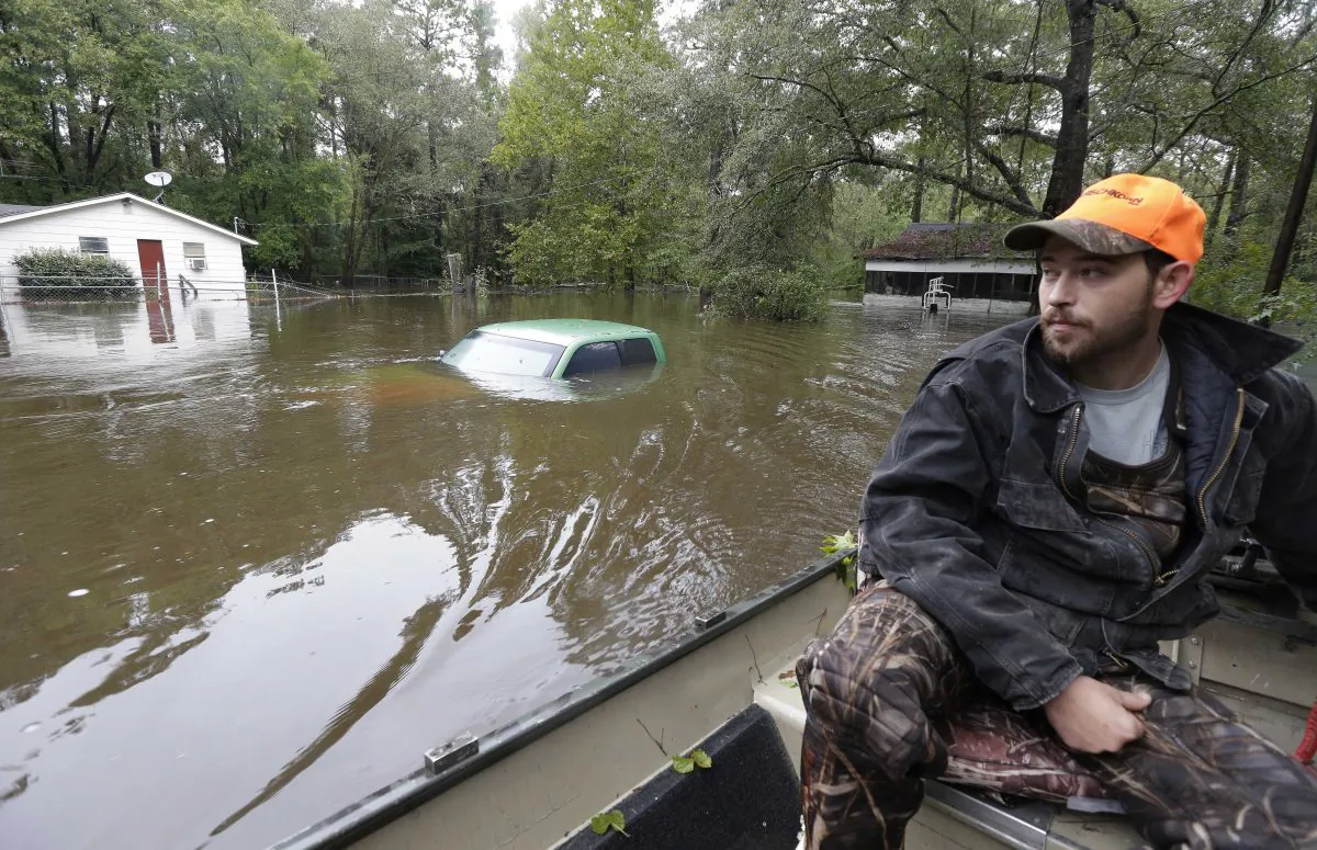 Hunter Baker surveys flood damage to his neighborhood near the flooded Black Creek following heavy rains in Florence, S.C., Monday, Oct. 5, 2015.  (AP Photo/Gerry Broome)