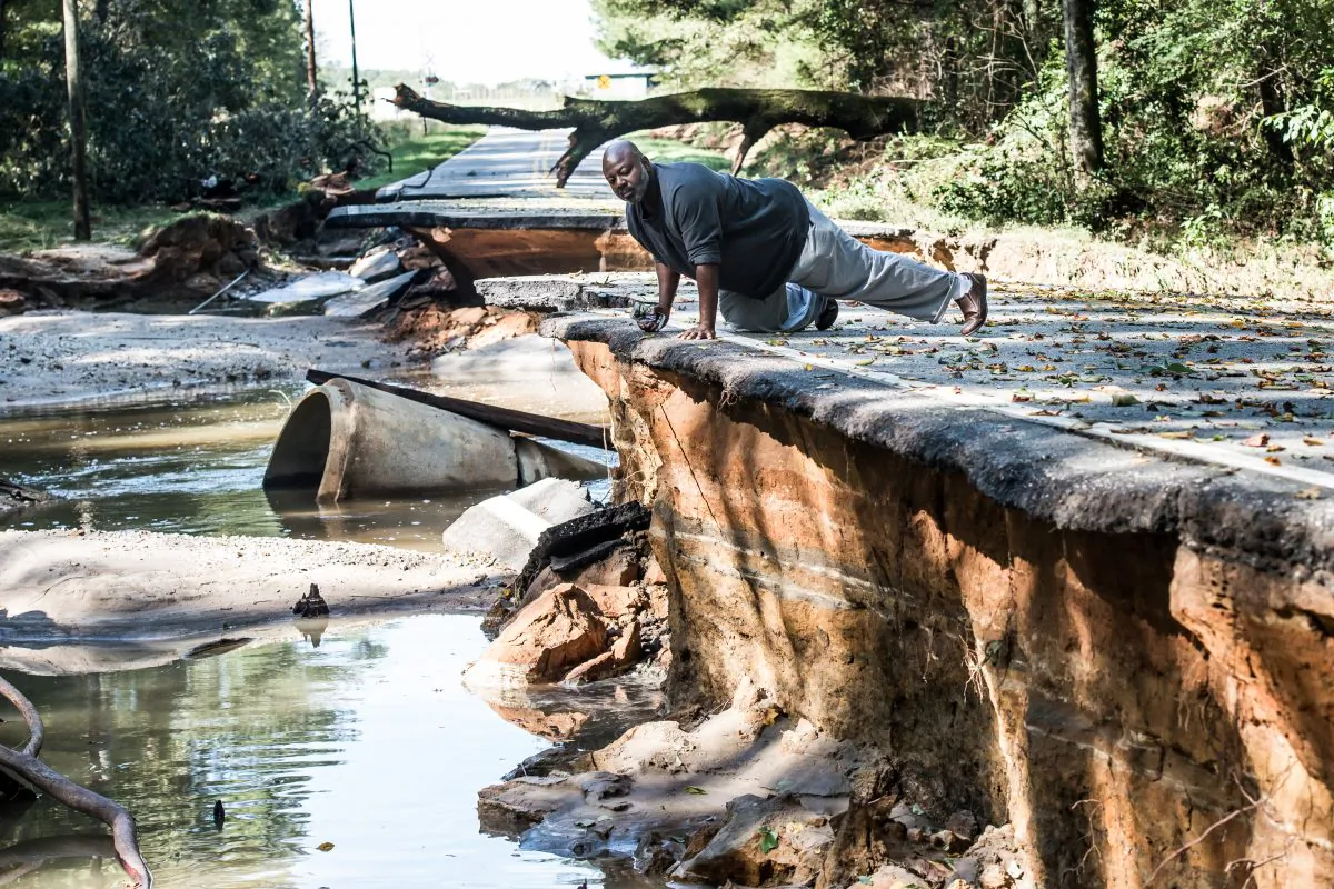 Trey McMillian looks over the damage done by flood waters on a road in Eastover in Eastover, S. C., on October 6, 2015. (Sean Rayford/Getty Images)