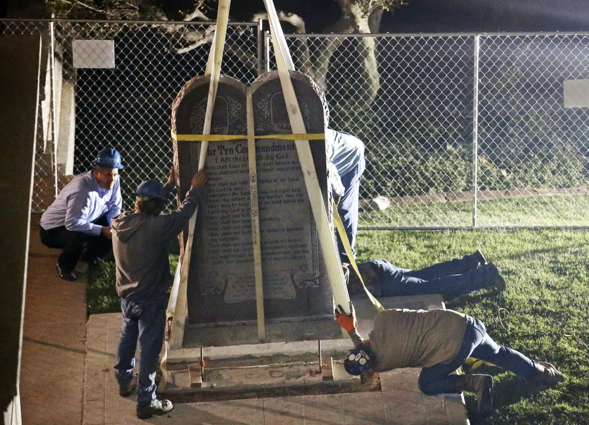 Workers remove the Ten Commandments monument from its base on the grounds of the state Capitol in Oklahoma City, Monday, Oct. 5, 2015.  (AP Photo/Sue Ogrocki)