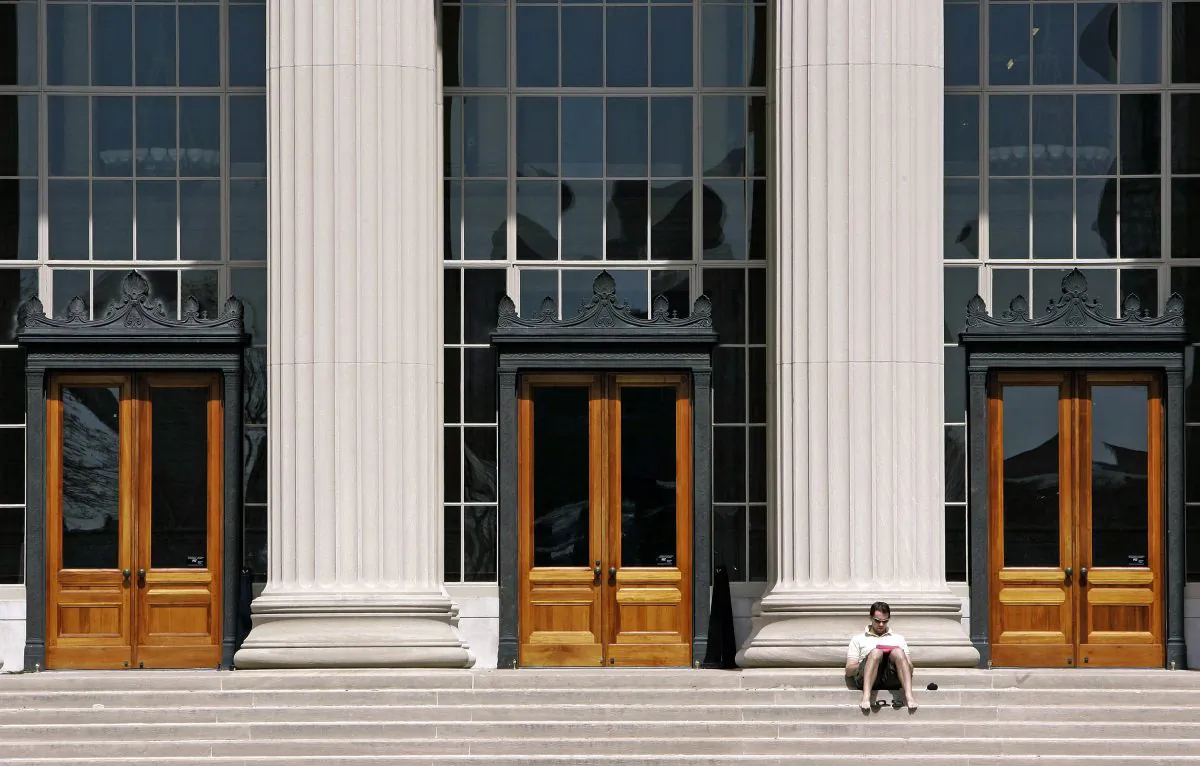 A doctoral student at the Massachusetts Institute of Technology reads outside a building at the Cambridge, Mass. campus, on April 22, 2007. (AP Photo/Michael Dwyer, File)
