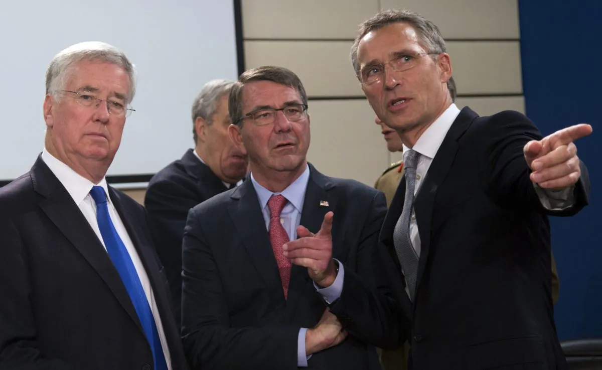 (R-L) NATO Secretary General Jens Stoltenberg, speaks with U.S. Secretary of Defense Ash Carter and British Secretary of State for Defense Michael Fallon during a meeting of the North Atlantic Council at NATO headquarters in Brussels on Thursday, Oct. 8, 2015. (AP Photo/Virginia Mayo)