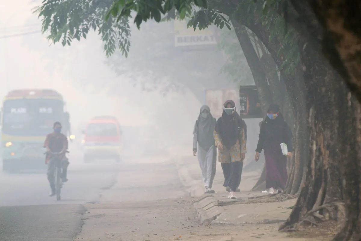 Indonesian pedestrians and a cyclist (L) wear face masks to protect against air pollution in Palembang, South Sumatra province, on October 8, 2015. (Abdul  Qodir/AFP/Getty Images)