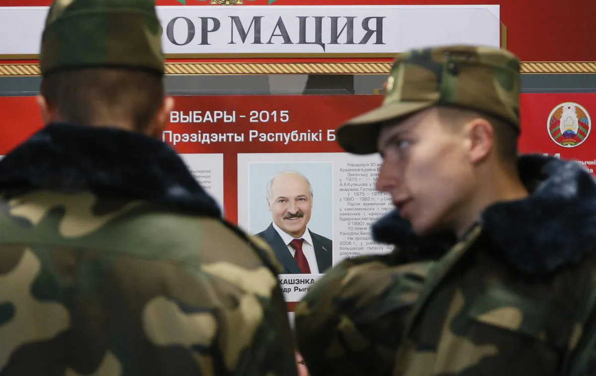 Belarusian army soldiers examine a candidates list with a portrait of Belarusian President Alexander Lukashenko at a polling station during presidential elections in Minsk, Belarus, Sunday, Oct. 11, 2015. (AP Photo/Dmitry Lovetsky)