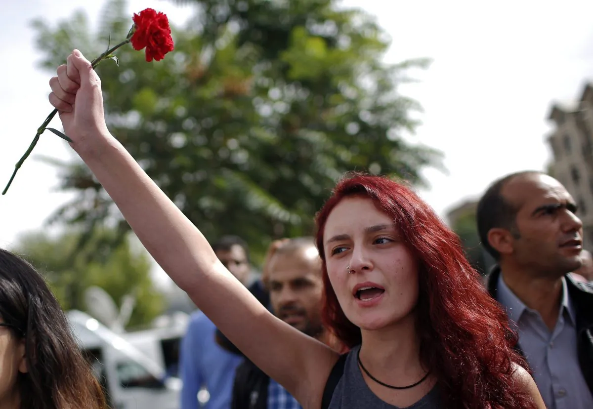 A woman participates at a memorial service for the victims of Saturday's attacks , at the site of the bombings in Ankara, Turkey, Monday, Oct. 12, 2015. (AP Photo/Emrah Gurel)