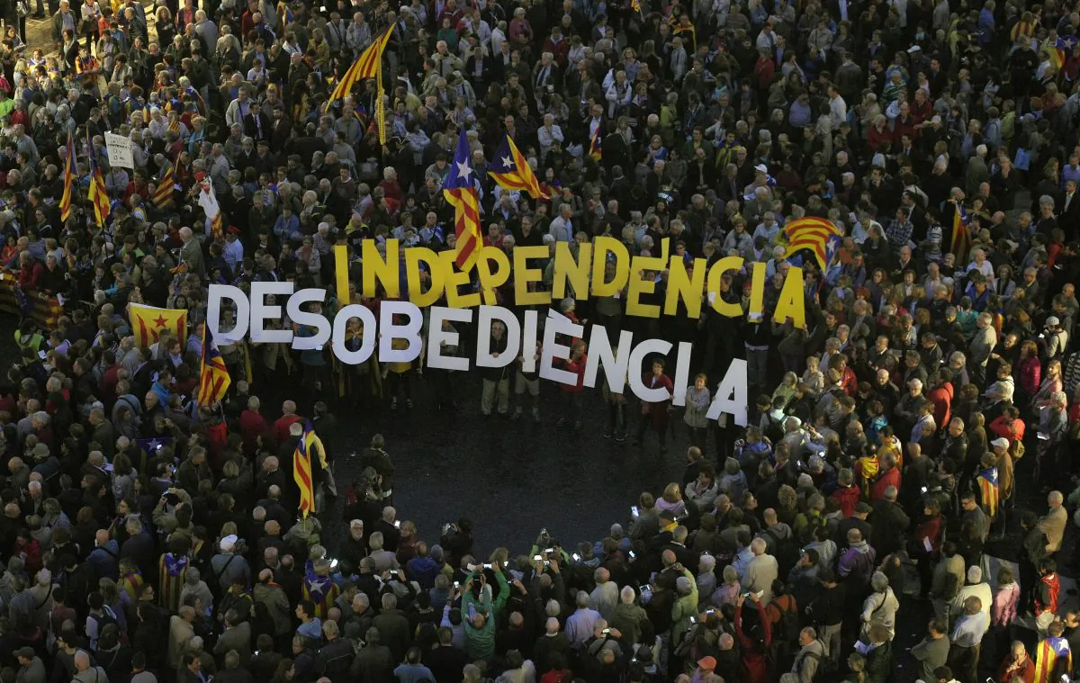 People gather with two banners that read " Independece" and "disobedience" during a protest outside Barcelona's City Council on October 13, 2015. (LLUIS GENE/AFP/Getty Images)