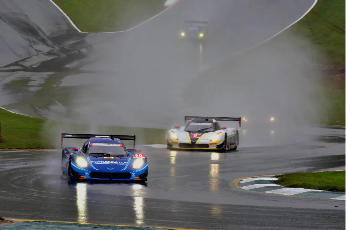 The #90 VisitFlorida.com Spirit of Daytona Coyote-Corvette leads the #5 Mustang Sampling Action Express Coyote-Corvette up the hill through the spray towards Road Atlanta’s Turn Five during the 2015 Tudor United Sportscar Championship petit le mans endurance race. (Bill Kent/Epoch Times)
