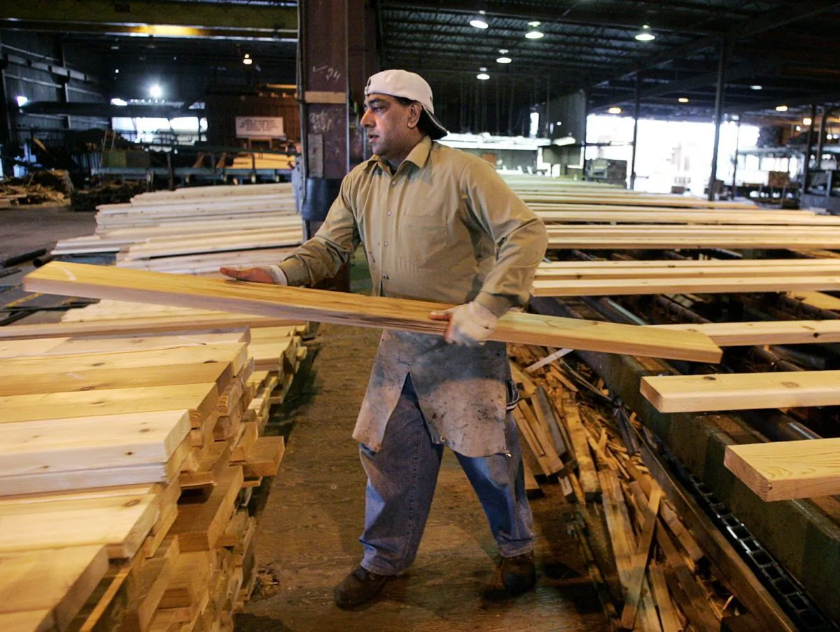 A worker sorts lumber at the Pan-Abode Mill in Richmond, B.C., Canada on April 27, 2006. (CP PHOTO/Chuck Stoody)