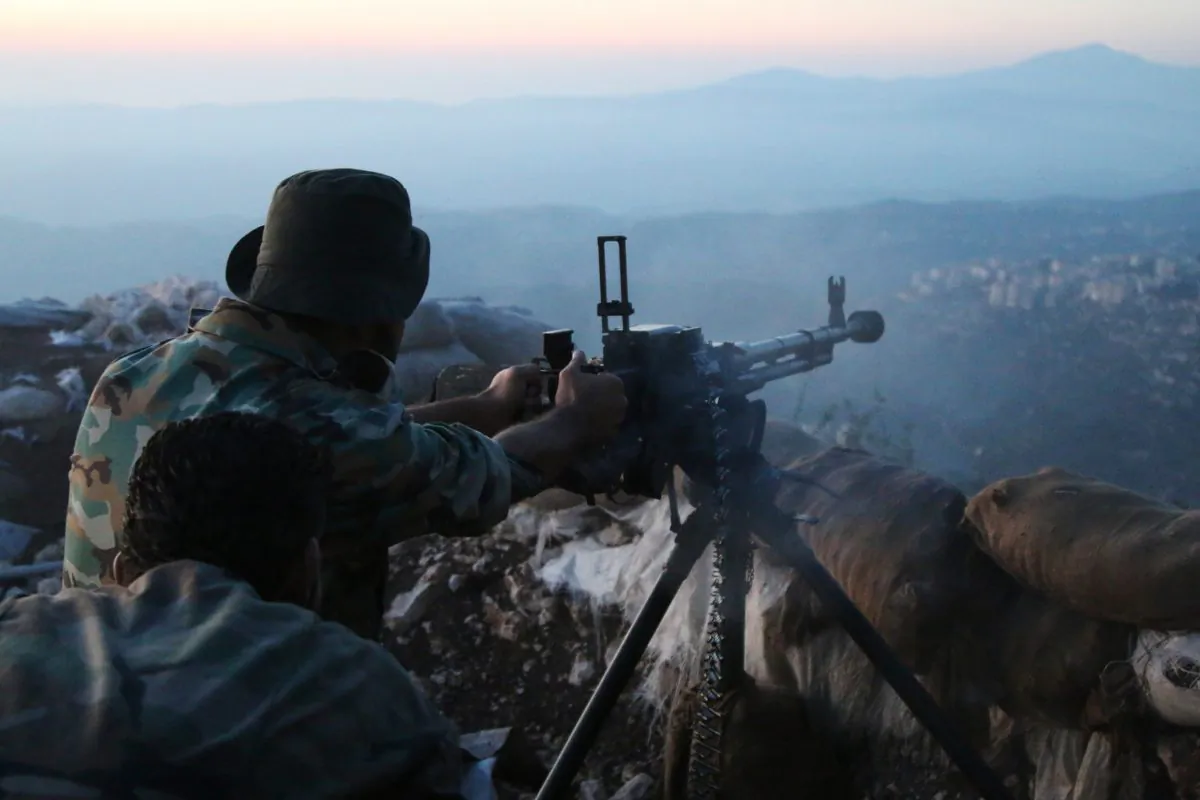 Syrian army personnel fire a machine gun in Latakia Province, Syria, about 12 miles from the border with Turkey, on Oct. 10, 2015. (Alexander Kots/Komsomolskaya Pravda via AP)