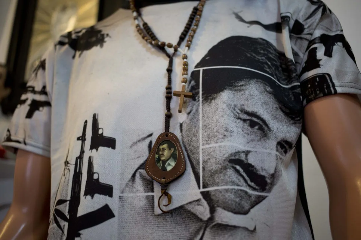 A T-shirt of fugitive Mexican drug lord Joaquin "El Chapo" Guzman covers a mannequin representing Jesus Malverde, known in Mexico as the "saint" of drug traffickers, inside the shrine of a faith healer in Mexico City, on Oct. 16, 2015. The government is offering a reward of 60 million pesos (about $3.5 million) for Guzman's recapture after he made his second escape from a maximum security prison through an underground tunnel in 2015. (AP Photo/Eduardo Verdugo)