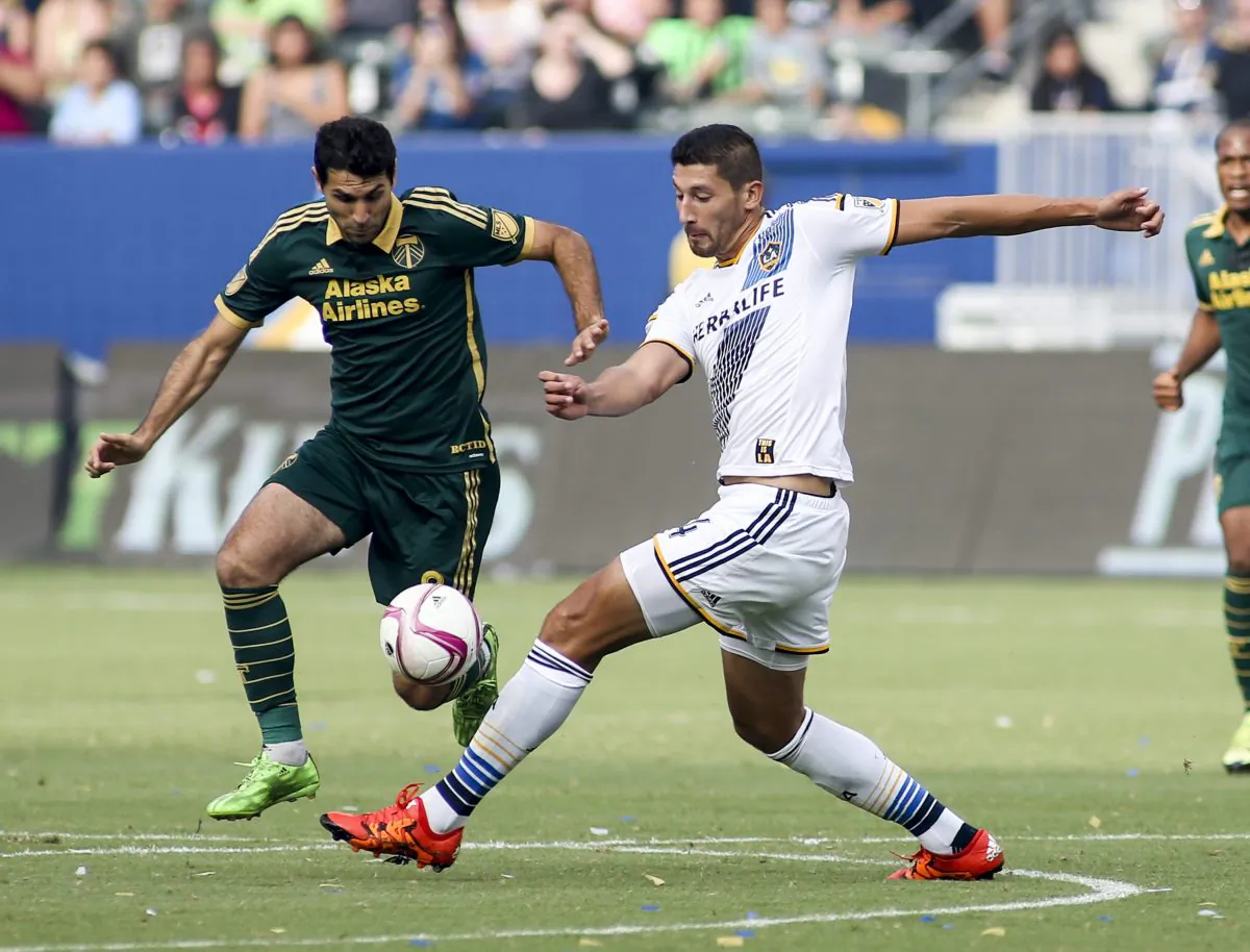 Portland Timbers midfielder Diego Valeri (L) and Los Angeles Galaxy defender Omar Gonzalez compete for a ball in MLS action in Carson, Calif., on Oct. 18, 2015. (AP Photo/Ringo H.W. Chiu)