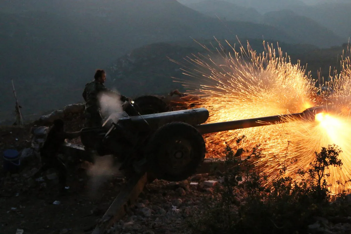 Syrian army personnel fire a cannon in Latakia Province, about 12 miles from the border with Turkey in Syria. Backed by Russian airstrikes, the Syrian army has launched an offensive in central and northwestern regions. (Alexander Kots/Komsomolskaya Pravda via AP)