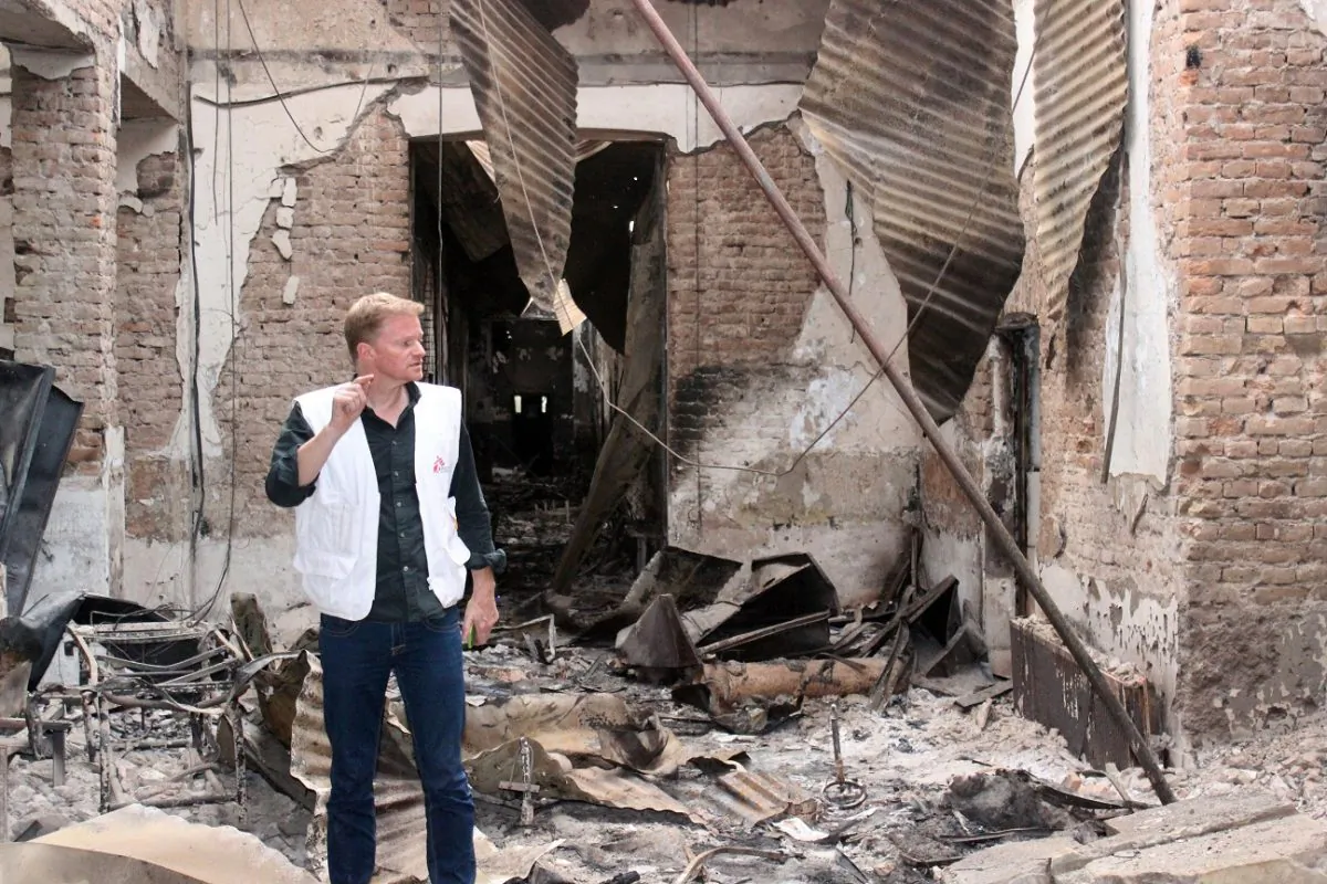 In this Friday, Oct. 16, 2015 photo, Christopher Stokes, the general director of the medical charity, Doctors Without Borders, which is also known by its French abbreviation MSF, stands amid the charred remains of the organization's hospital, after it was hit by a U.S. airstrike in Kunduz, Afghanistan.  (Najim Rahim via AP)