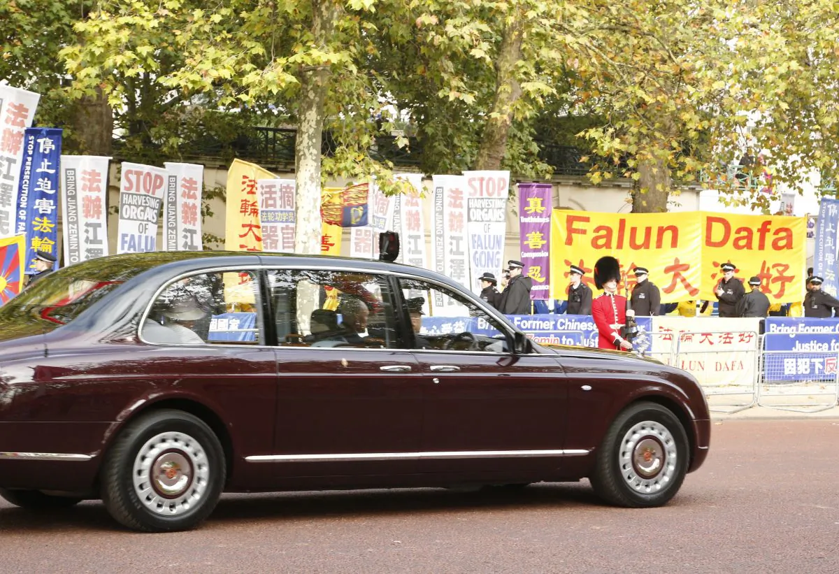The Queen arrives at Buckingham Palace on the Mall, passing by protesters including Falun Gong, Free Tibet, and Amnesty International (Si Gross/Epoch Times)