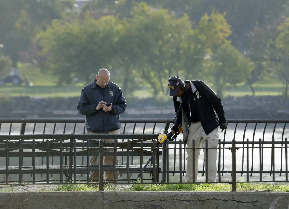Police officers work at the scene, Wednesday, Oct. 21, 2015, where NYPD Officer Randolph Holder was shot in the head and died during a gunfight and chase on Tuesday night, in New York. Holder was responding to a report of shots fired. A suspect in his slaying is in custody, police said Wednesday. (AP Photo/Seth Wenig)