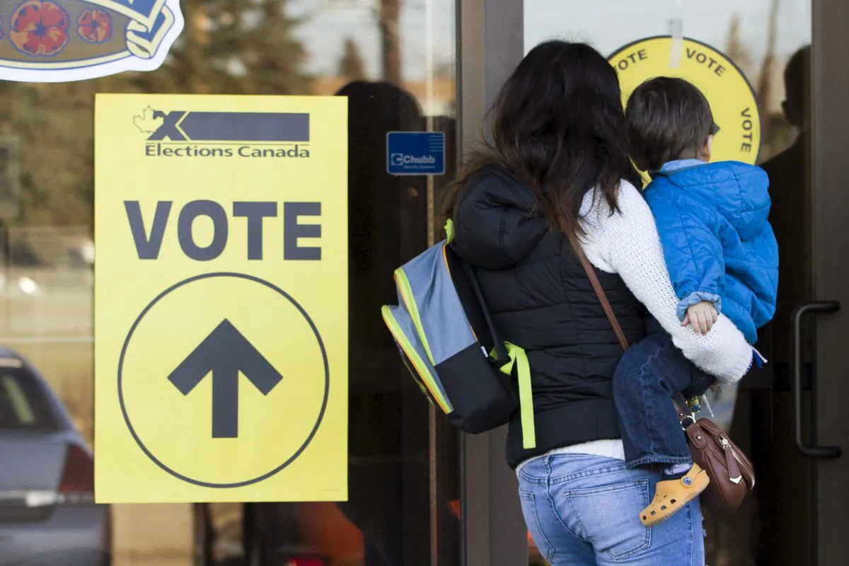 A woman holding a baby enters a polling station to vote in Calgary on Oct. 19, 2015. (REUTERS/Mark Blinch)