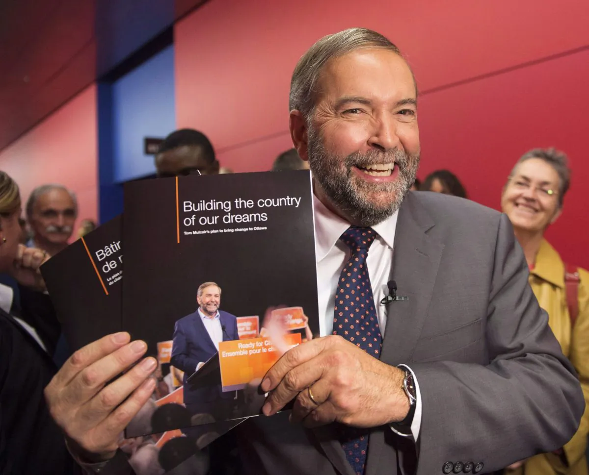 NDP leader Tom Mulcair holds up his party’s platform book at a town hall meeting on Oct. 9, 2015 in Montreal. Despite the outcome of the election, Mulcair isn’t planning on going anywhere. (THe Canadian Press/Ryan Remiorz)
