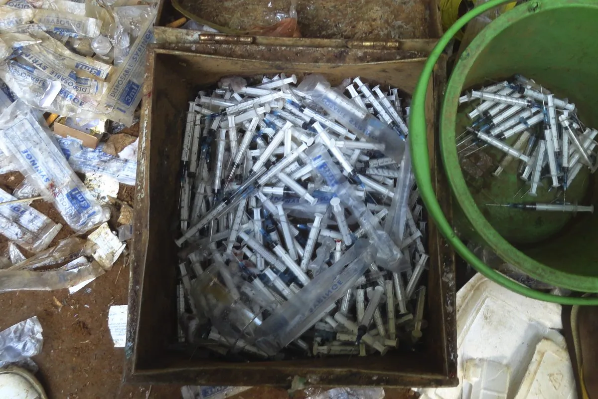 Syringes used to inject drugs are seen in a metal box and a plastic bucket in a tent near the jade mines surrounding Hpakant, in Kachin State, some 600 miles north of Yangon, Burma, in October 2014.  (AP Photo)