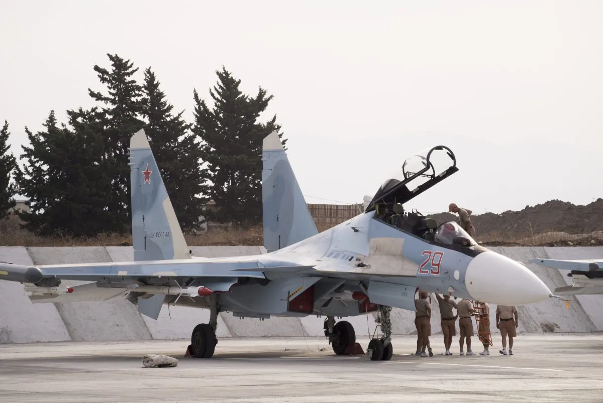 Russian air force personnel stand near a Russian war plane at Hemeimeem airbase, Syria, on Oct. 22, 2015. Nearly a quarter of a century after the Soviet collapse, the air campaign in Syria has proven that the resurgent Russian military machine could again operate far away from the nation's borders. (AP Photo/Vladimir Isachenkov)