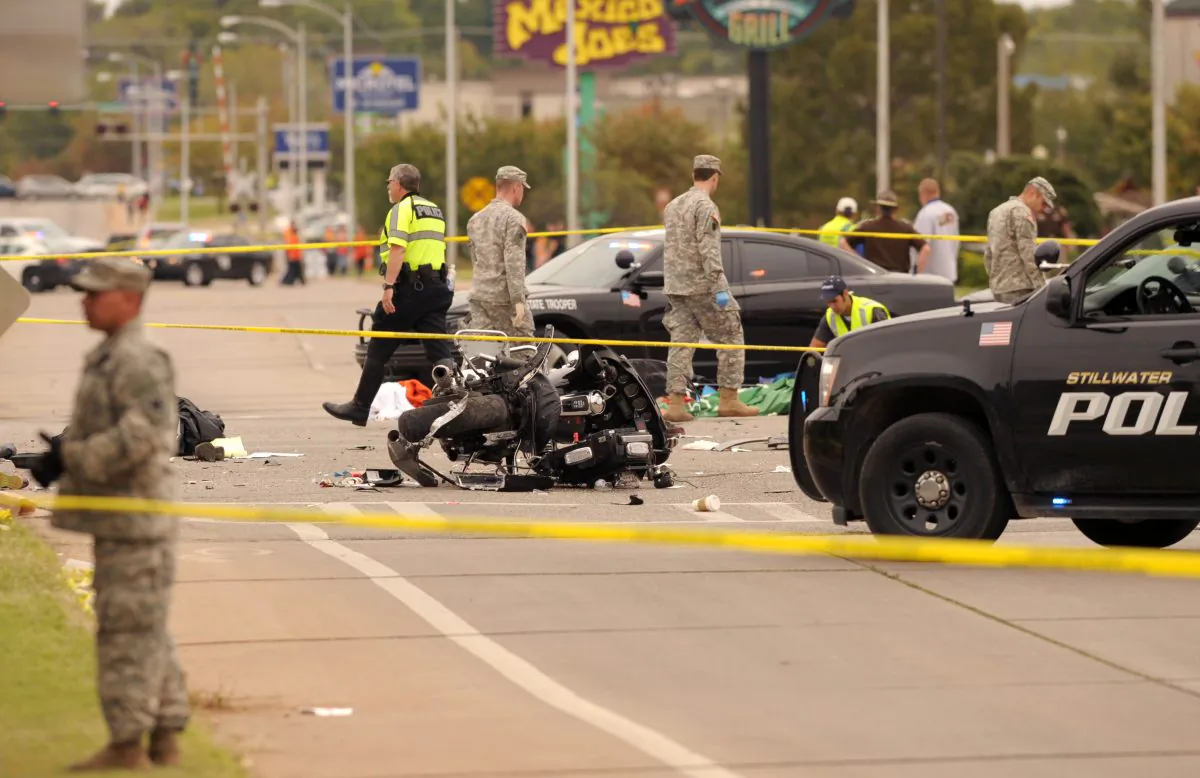 A damaged police motorcycle rests in the intersection after a vehicle crashed into a crowd of spectators during the Oklahoma State University homecoming parade, causing multiple injuries, in Stillwater, Oka., on Oct. 24, 2015. (AP Photo/Brody Schmidt)