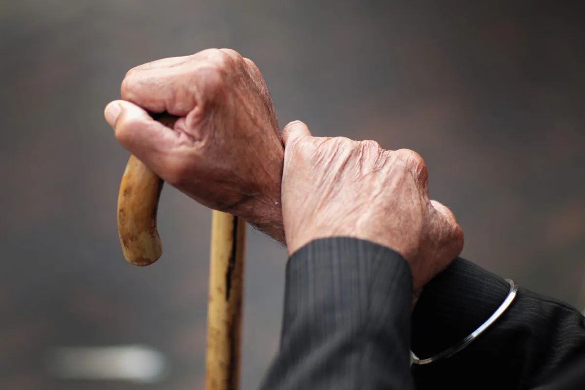 A pensioner holds his walking stick in this file photo. (Christopher Furlong/Getty Images)