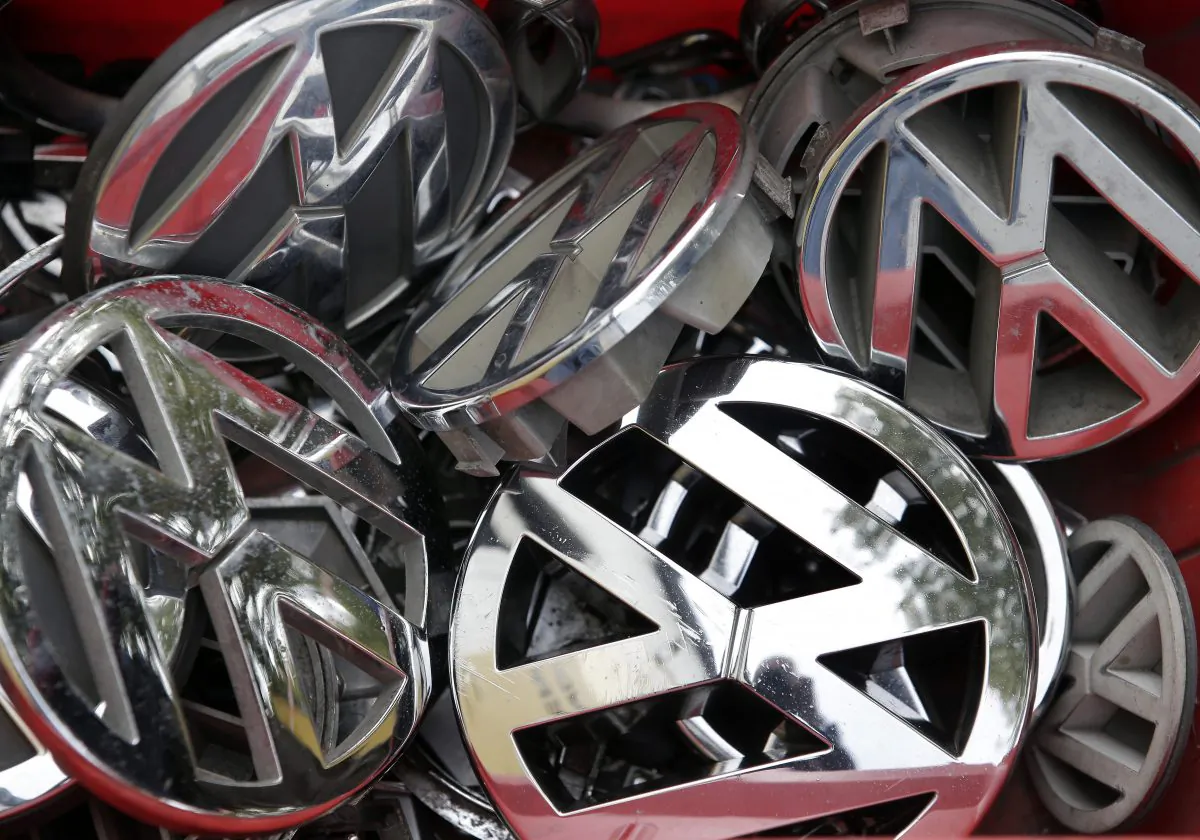 Company logos of the German carmaker Volkswagen sit in a box at a scrap yard in Berlin, Germany, on Sept. 23, 201. (AP Photo/Michael Sohn)