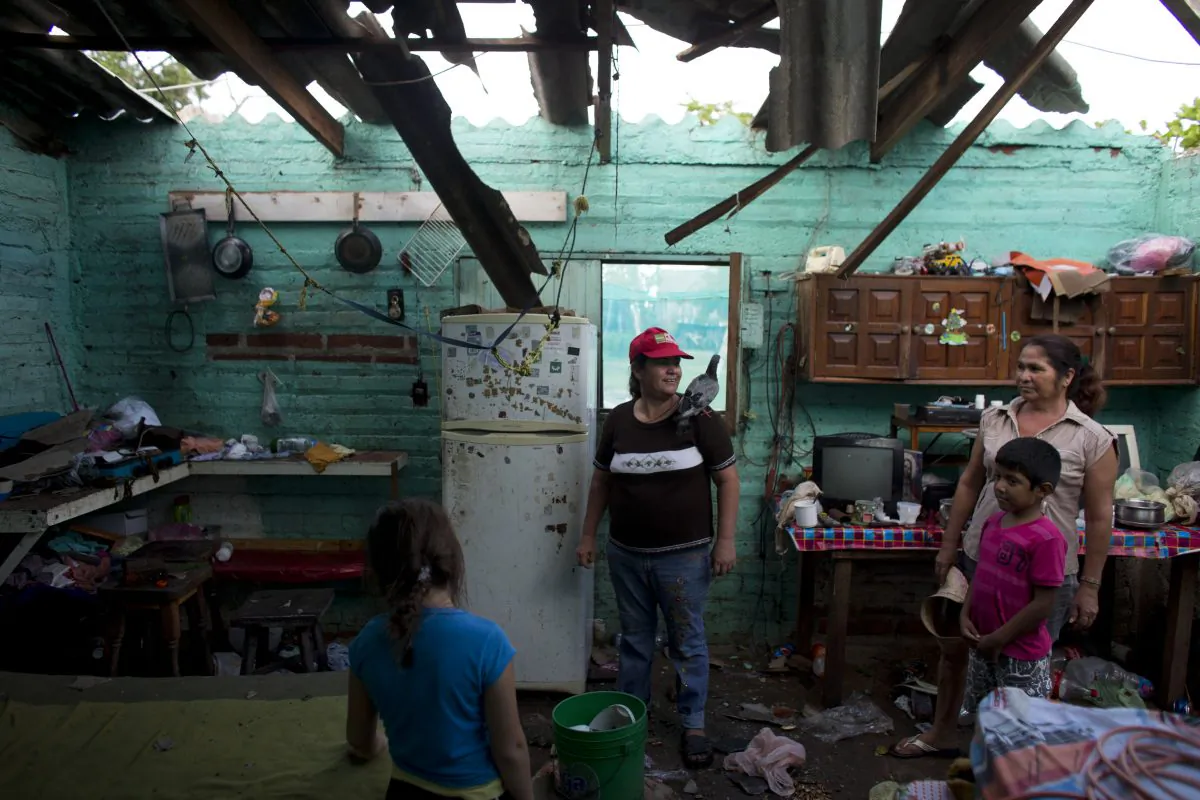 Josefina Magana Ruiz, center, surveys her home damaged by Hurricane Patricia, in La Fortuna, Mexico, Saturday, Oct. 24, 2015.  (AP Photo/Rebecca Blackwell)