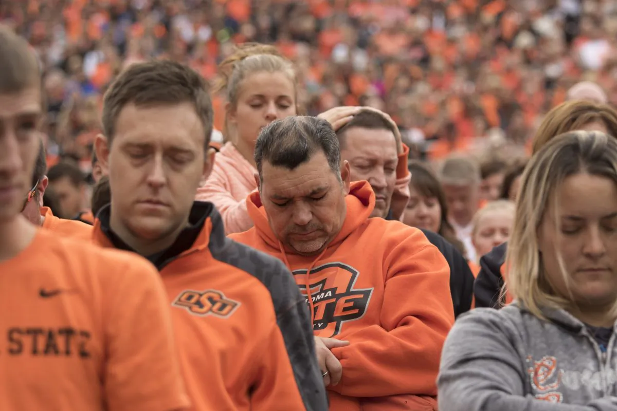 Oklahoma State football fans observe a moment of silence for the people killed by a car that crashed into the homecoming parade, during a NCAA college football game against the Kansas Jayhawks, at the Boone Pickens Stadium in Stillwater, Oklahoma, on Oct. 24, 2015. (J. Pat Carter/Getty Images)