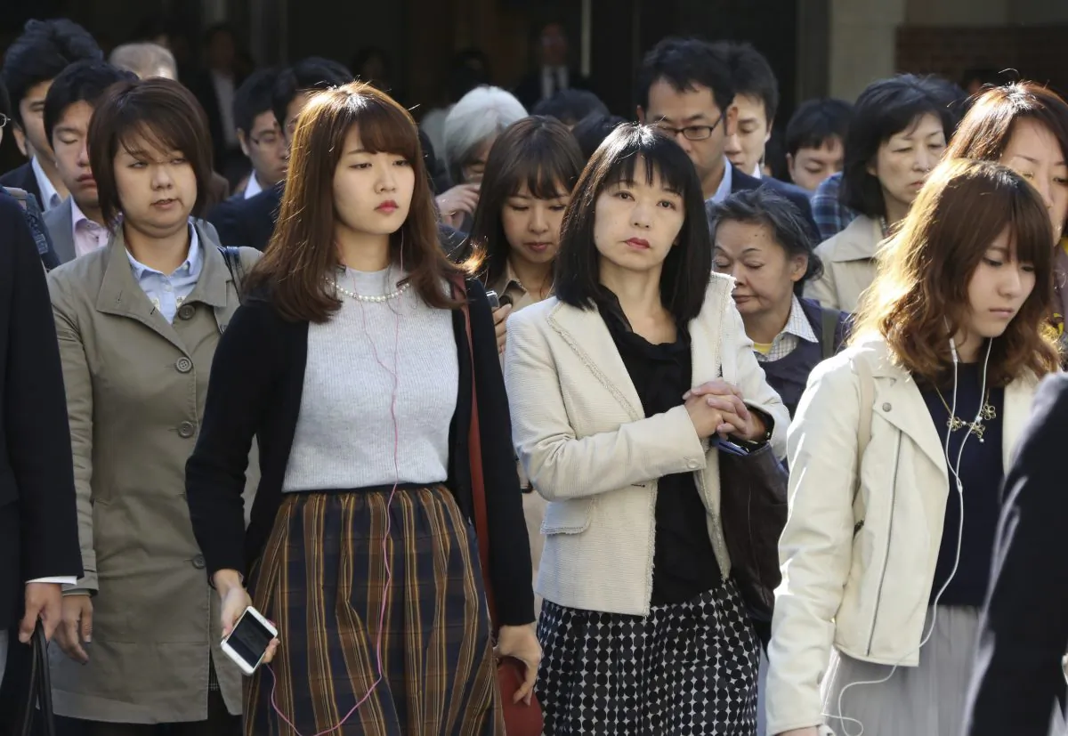 Commuters cross a street during morning rush hour in Tokyo, on Monday, Oct. 26, 2015. (AP Photo/Koji Sasahara)