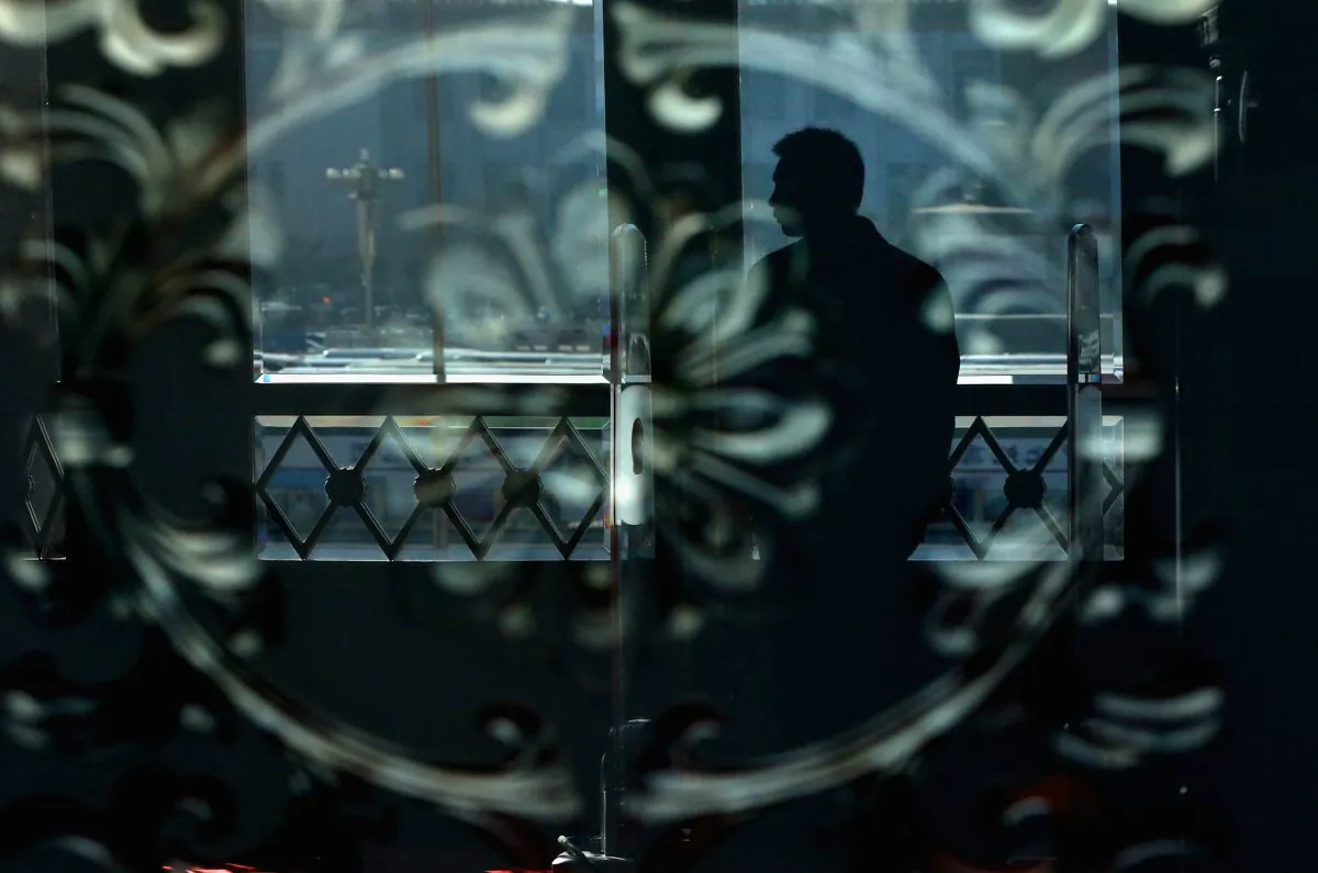An usher stands guard reflected in a glass door at the Great Hall of the People in Beijing on March 10, 2013. (Feng Li/Getty Images)