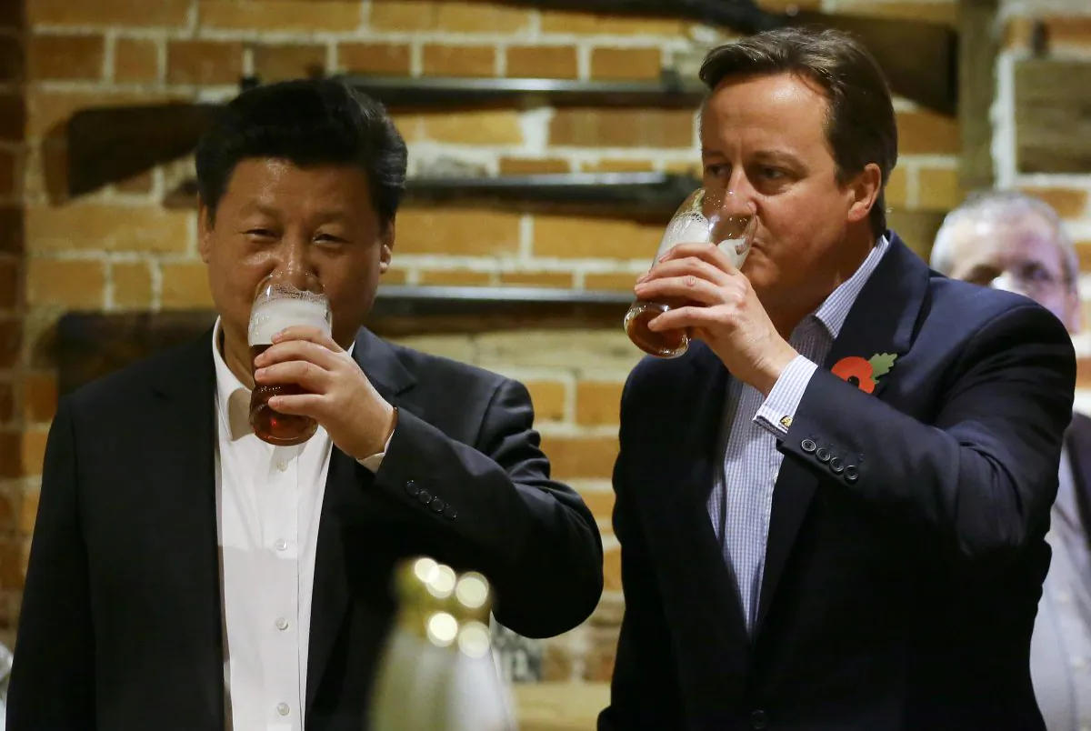 China's leader Xi Jinping (L) and then Prime Minister David Cameron drink a pint of beer during a state visit to the UK at a pub in Princess Risborough near Chequers, northwest of London, on Oct. 22, 2015. (Kirsty Wigglesworth/WPA Pool/Getty Images)