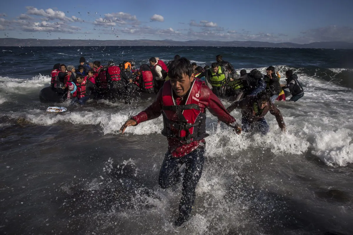 Afghan migrants disembark safely from their frail boat in bad weather on the Greek island of Lesbos after crossing the Aegean see from Turkey, Wednesday, Oct. 28, 2015. (AP Photo/Santi Palacios)