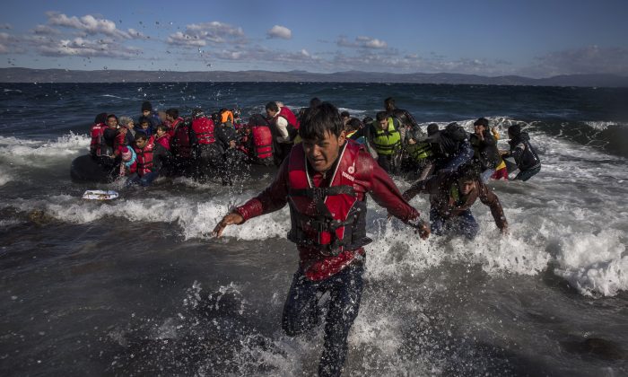 Afghan migrants disembark safely from their frail boat in bad weather on the Greek island of Lesbos after crossing the Aegean see from Turkey, Wednesday, Oct. 28, 2015. (AP Photo/Santi Palacios)