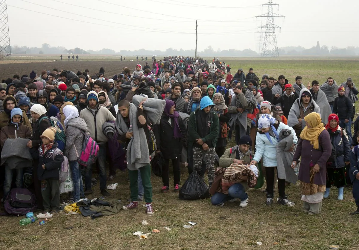 Migrants move through fields after crossing from Croatia, in Rigonce, Slovenia, on Oct. 27, 2015. The European Union is lashing member countries for dragging their feet on providing funds and experts to help manage Europe's biggest refugee emergency in decades. (AP Photo/Darko Bandic)