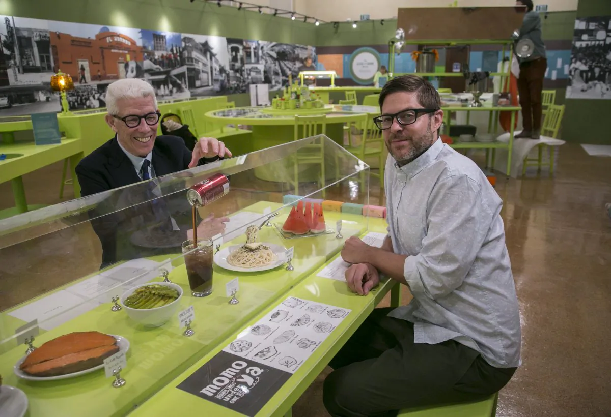 Library Foundation of Los Angeles President Ken Brecher (L) and Josh Kun, editor and curator, sit down at the "Invisible Kitchen" installation by artist Haruko Tanaka, part of the exhibit "To Live and Dine in L.A." at the Los Angeles Public Library, in Los Angeles, on June 12, 2015. Two LAPL librarians began collecting menus in the 1980s. Today the library is in possession of about 15,000 menus, the oldest dating back to 1875. (AP Photo/Damian Dovarganes)