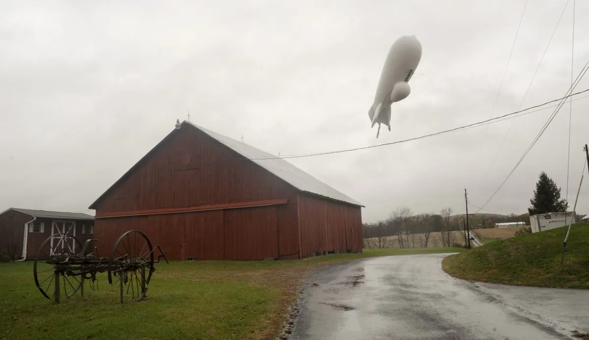 An unmanned Army surveillance blimp floats through the air while dragging a tether line south of Millville, Pa., Wednesday, Oct. 28, 2015. (Jimmy May/Bloomsburg Press Enterprise via AP)