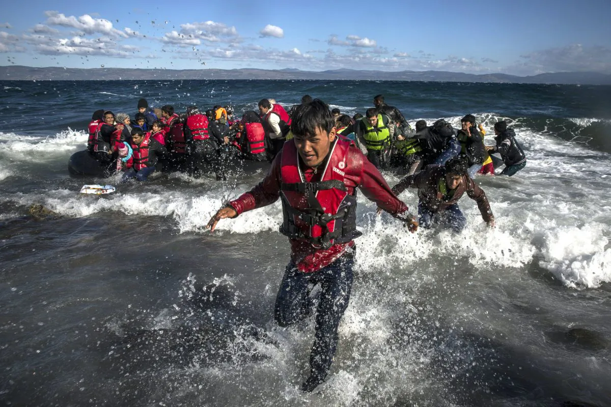 Afghan migrants disembark safely from their frail boat in bad weather on the Greek island of Lesbos after crossing the Aegean see from Turkey, Wednesday, Oct. 28, 2015. (AP Photo/Santi Palacios)