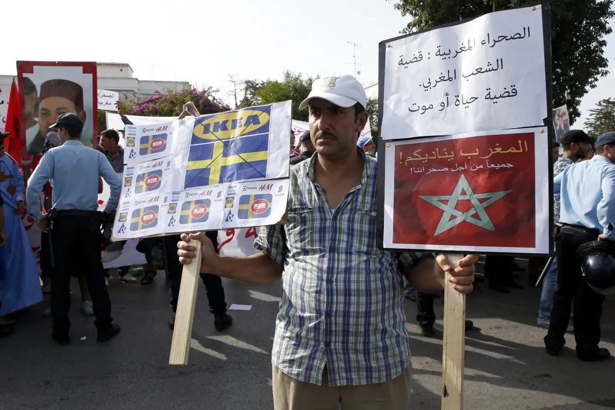 A man holds a placard with Swedish companies and flags with legend in Arabic reading "The Moroccan Sahara is Moroccan case a matter of life or death", as some thousands of Moroccans protest outside the Swedish Embassy in Rabat, Morocco, on Oct. 4, 2015. As it marks 40 years since taking control of the mineral-rich Western Sahara, the Moroccan government has been pursuing an especially forceful foreign policy aimed at confronting any challenges to its claims on the territory. And Sweden has become its main target. (AP Photo/Abdeljalil Bounhar)