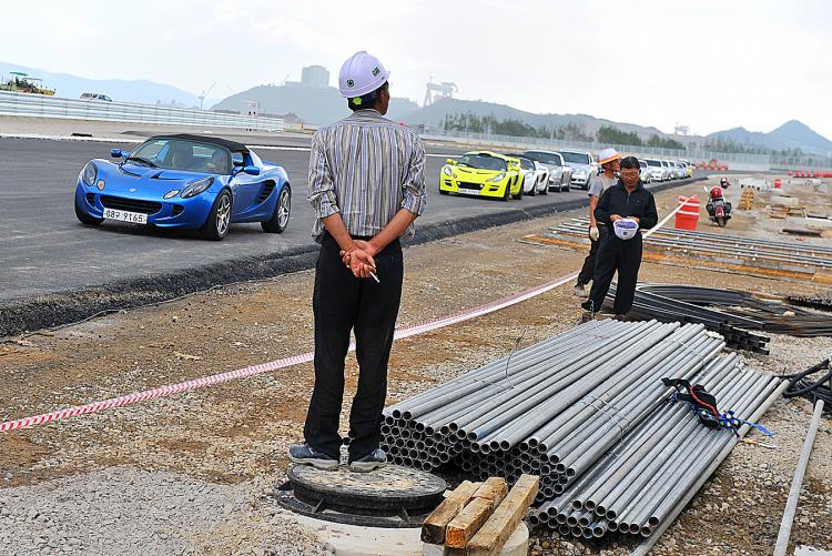 Workers watches a parade of sports cars at the Korean International Circuit, under construction for the upcoming Formula 1 Korean Grand Prix, Sept. 4, 2010. (Jung Yeon-Je/AFP/Getty Images) Workers watches a parade of sports cars at the Korean International Circuit, under construction for the upcoming Formula 1 Korean Grand Prix, Sept. 4, 2010. (Jung Yeon-Je/AFP/Getty Images)