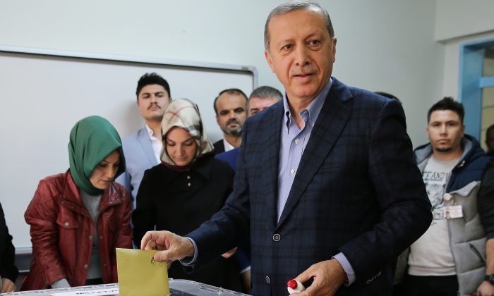 Turkey's President Recep Tayyip Erdogan casts his vote at a polling station, in Istanbul, Sunday, Nov. 1, 2015. (AP Photo/Hussein Malla)
