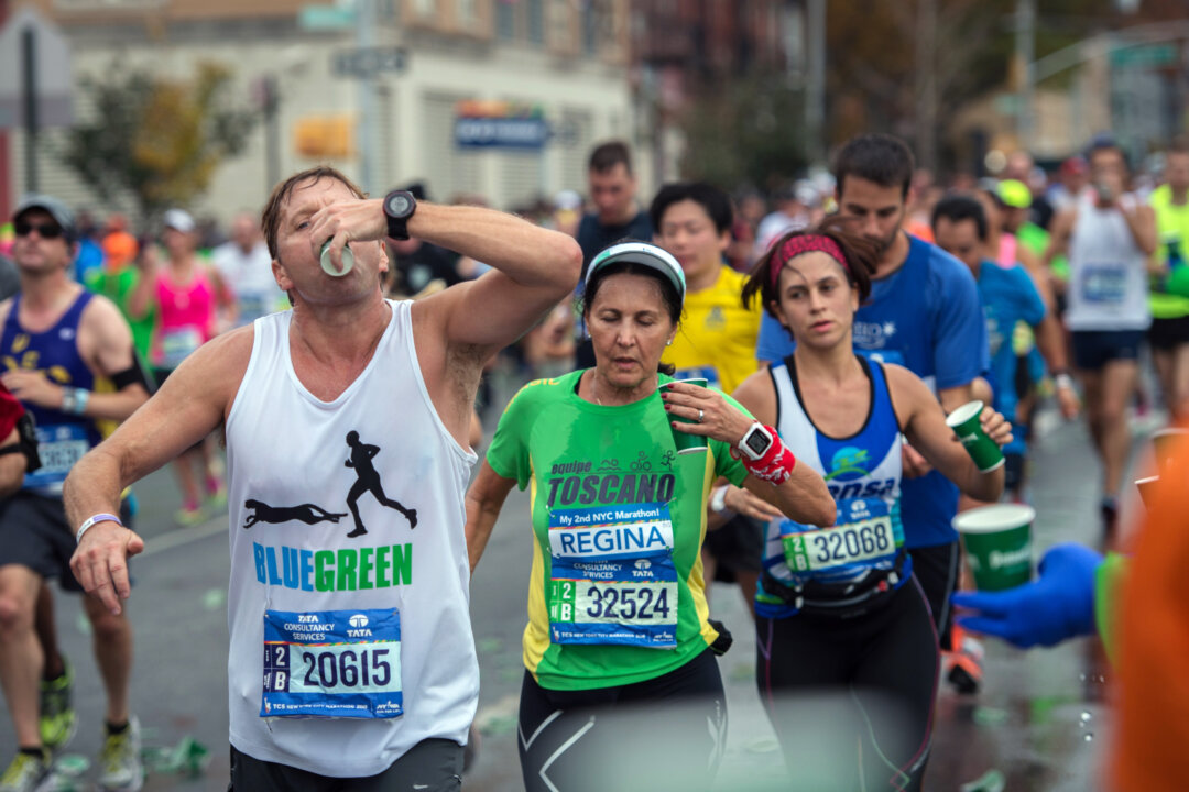 Runners pass through a water station during the New York City Marathon, Sunday, Nov. 1, 2015, in the Brooklyn borough of New York. (AP Photo/Bryan R. Smith)