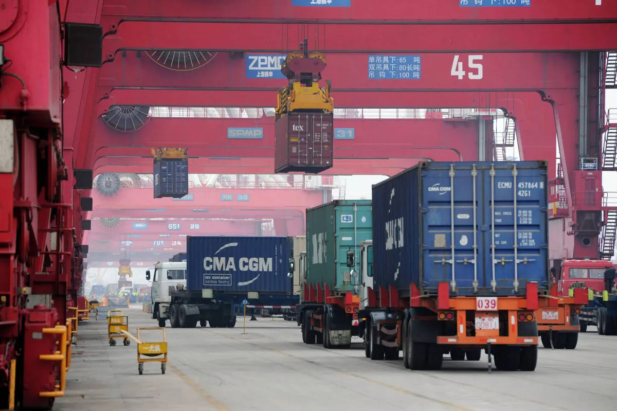 Trucks move shipping containers in the container pool of a seaport in Qingdao in eastern China's Shandong Province on July 1, 2015. (Chinatopix via AP)