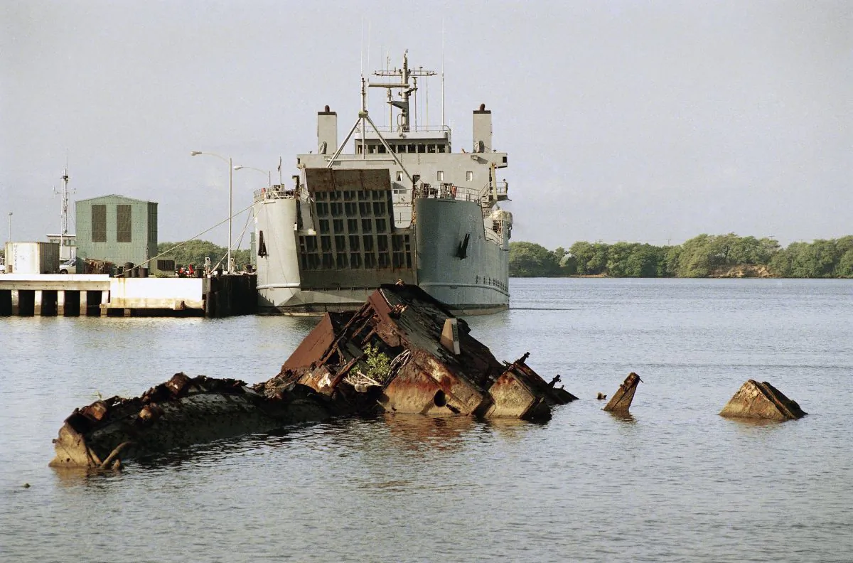 Entombed at Pearl Harbor, the remains of the USS Utah are seen in the foreground, with its eroded hulk lying in waters on the northwestern side of Ford Island, Hawaii on Nov. 22, 1991. (AP Photo/Eric Risberg)