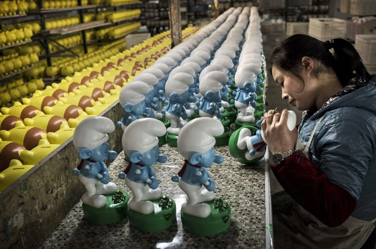 Chinese workers paint unfinished licensed ceramic 'Smurfs' at the Shunmei Group (SMG) ceramics factory during a tour on December 7, 2014 in Dehua, Fujian Province, China. (Kevin Frayer/Getty Image) 