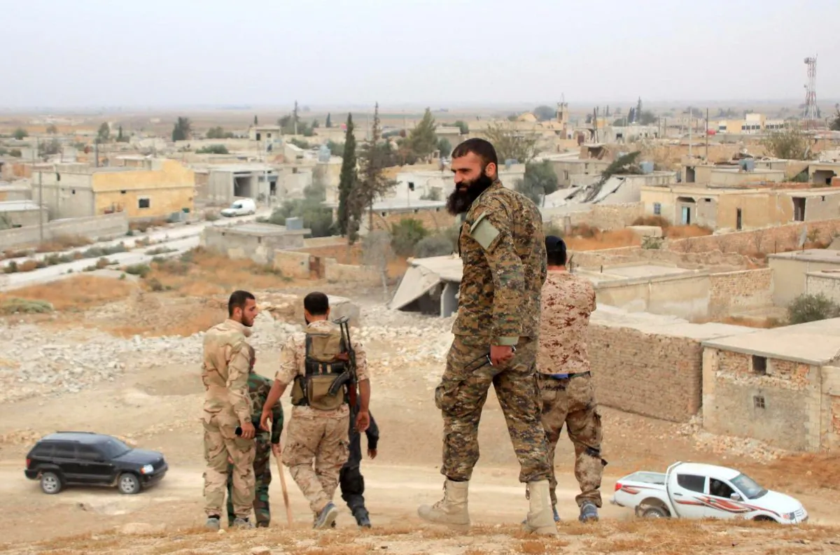 Syrian government forces walk in the village of Jabboul on the eastern outskirts of the northern Syrian city of Aleppo after taking control of the village from Islamic State (ISIS) group islamists on Oct. 24, 2015. (George Ourfalian/AFP/Getty Images)