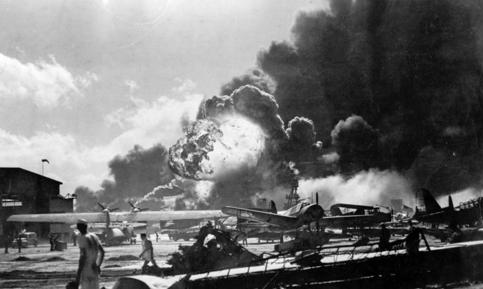 U.S. Sailors stand amid wreckage watching as the USS Shaw explodes on Ford Island, Pearl Harbor, Hawaii, during the Japanese attack on Dec. 7, 1941. (Getty Images)