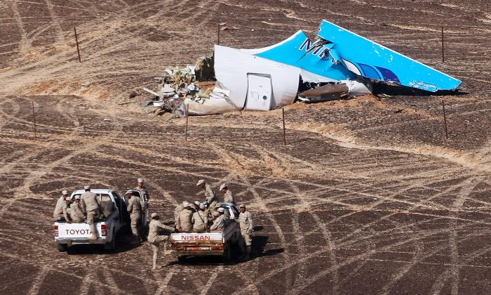 In this photo made available Monday, Nov. 2, 2015, and provided by Russian Emergency Situations Ministry, Egyptian Military on cars approach a plane's tail at the wreckage of a passenger jet bound for St. Petersburg in Russia that crashed in Hassana, Egypt, on Sunday, Nov. 1, 2015. (Maxim Grigoriev/Russian Ministry for Emergency Situations via AP)