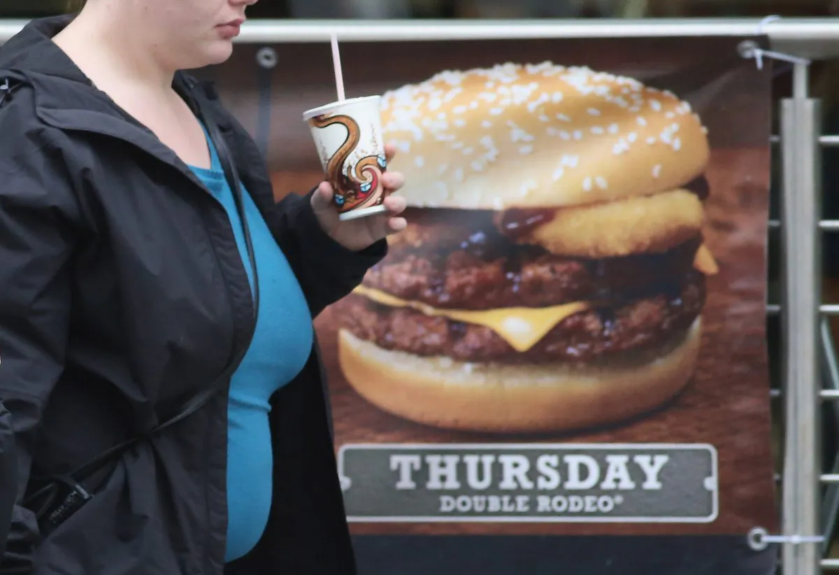 A woman passes an advertisement outside a fastfood outlet in Bristol, England, on Jan. 7, 2013. (Matt Cardy/Getty Images)