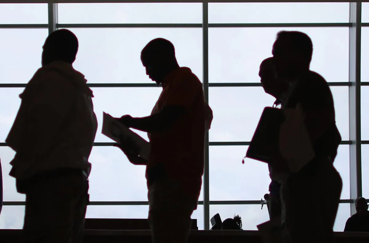 People looking for work stand in line to apply for a job during a job fair, in a file photo. (Joe Raedle/Getty Images)