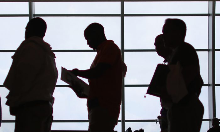People looking for work stand in line to apply for a job during a job fair, in a file photo. (Joe Raedle/Getty Images)
