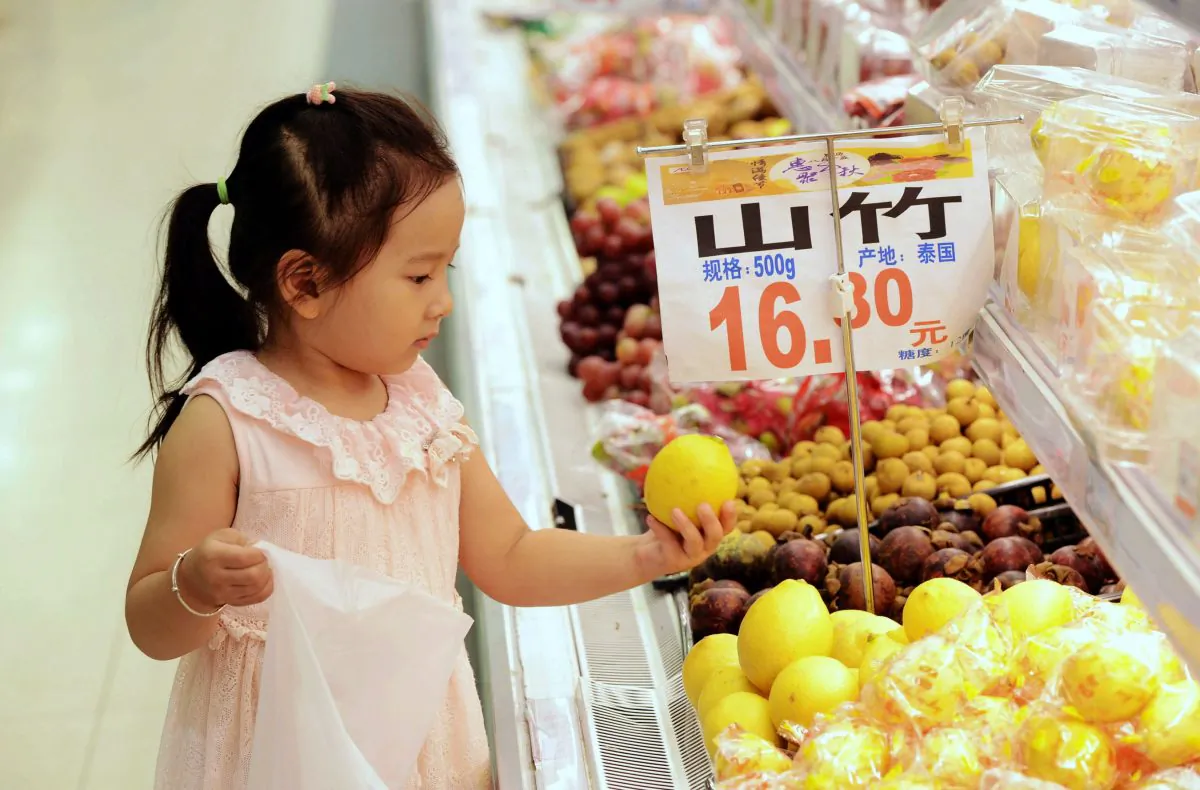 A young Chinese girl selects fruit at a supermarket in Qingdao, east China's Shandong Province on September 10, 2015. (STR/AFP/Getty Images)